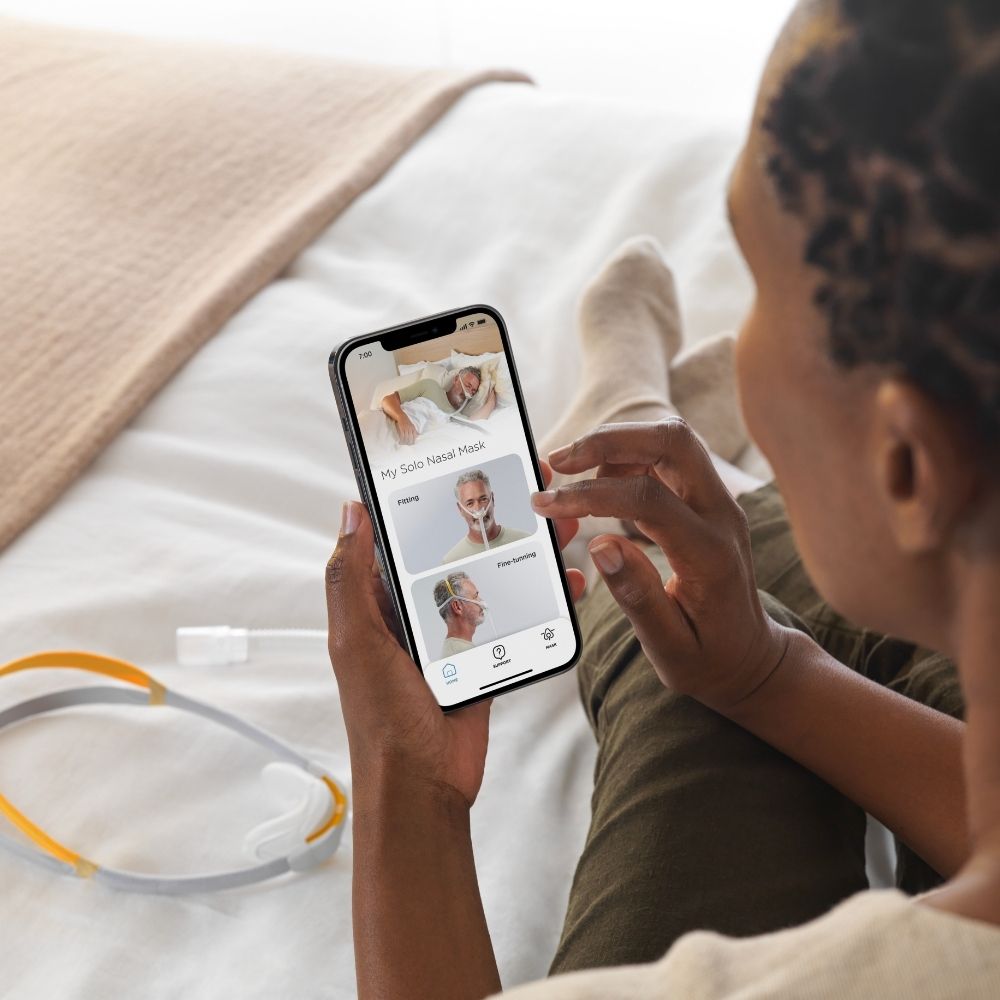 F&P myMask App being used by person sitting on their bed