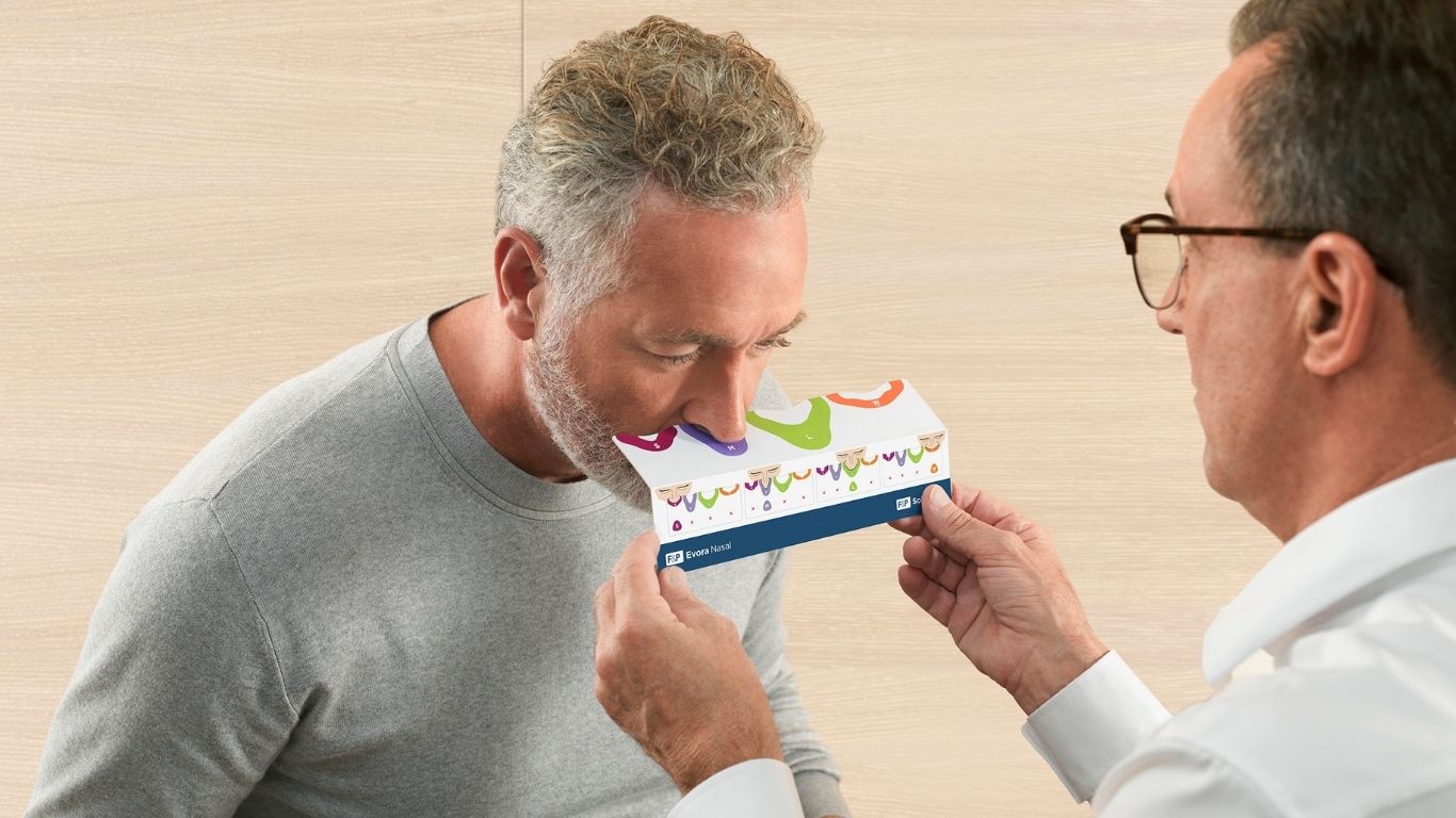 Man being sized for an F&P Evora nasal mask cushion by a clinician