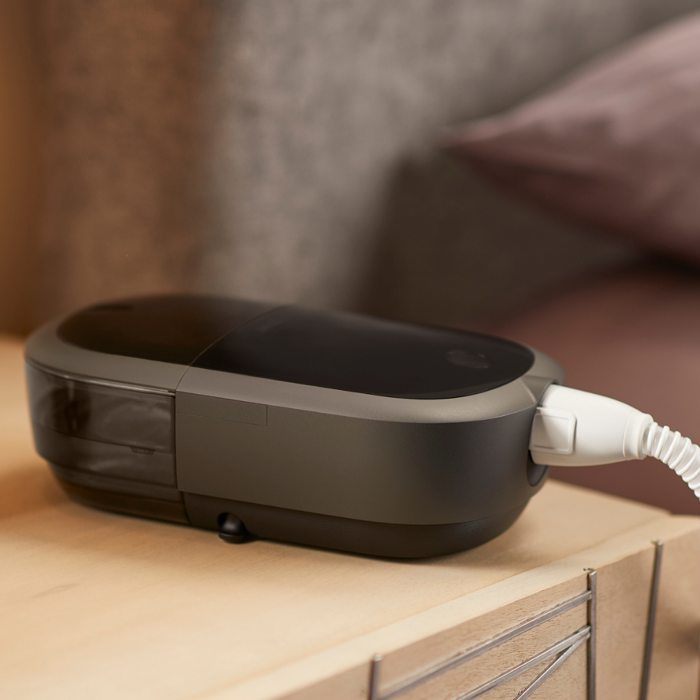 Philips DreamStation 2 CPAP machine on a wooden nightstand