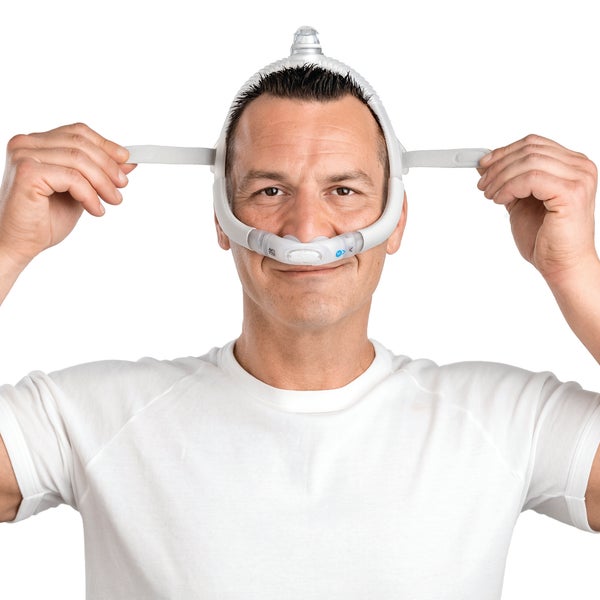 Person adjusting the headgear on the ResMed AirFit P30i nasal pillows CPAP mask