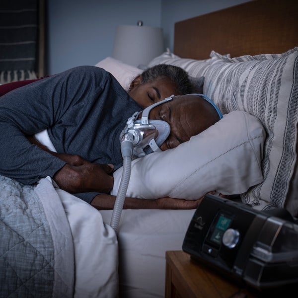 Person sleeping while wearing the ResMed AirTouch F20 full face CPAP mask