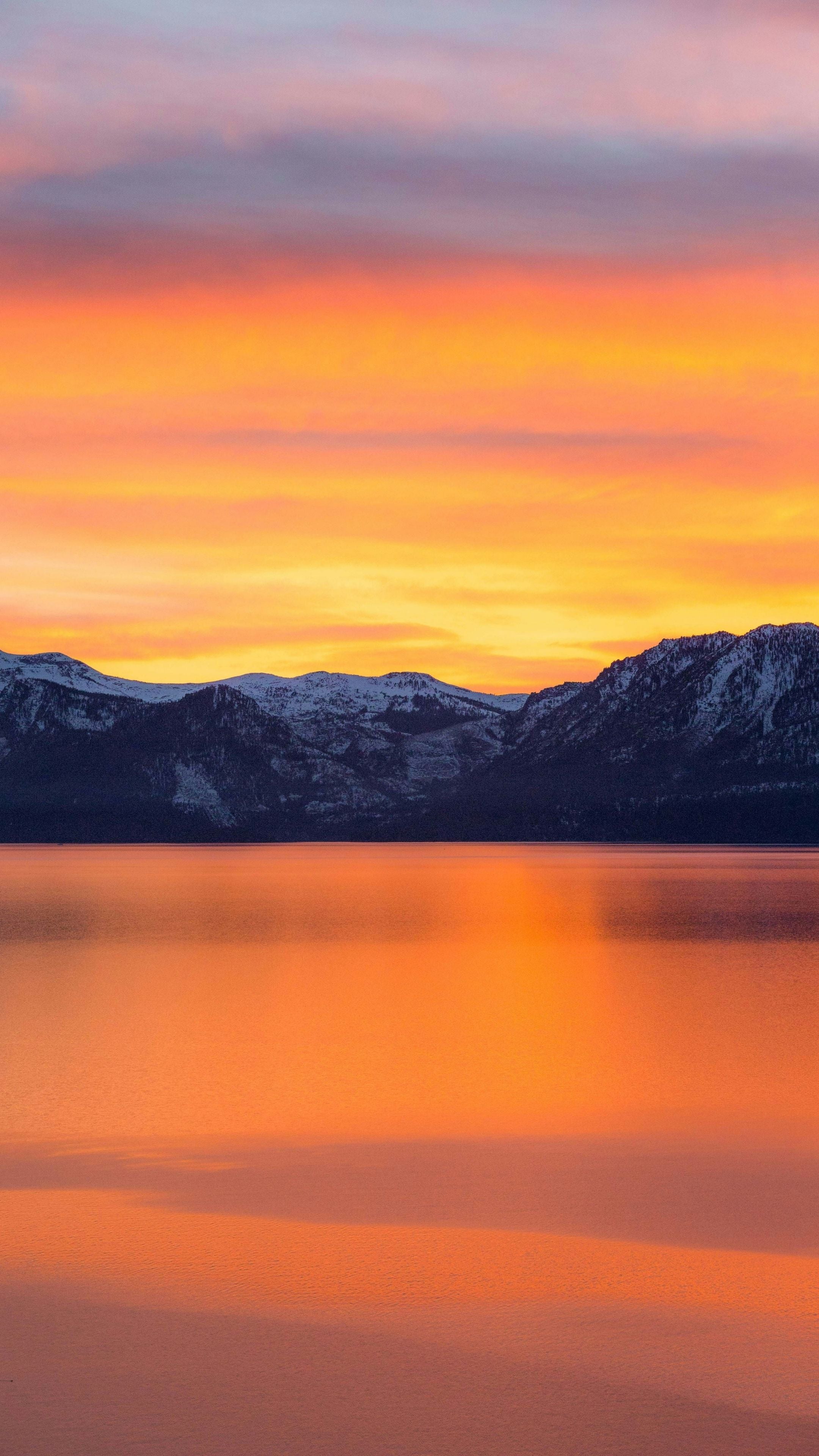 Resolve Sleep Health bright orange sunset over a lake with mountains in the background
