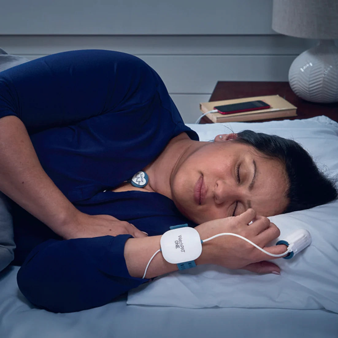 Person sleeping peacefully in bed at home with WatchPAT ONE device their wrist for sleep apnea testing