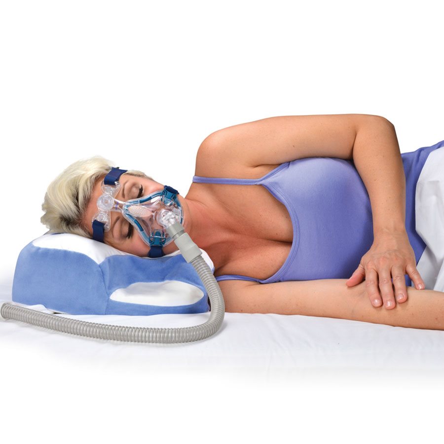 Person using the Contour CPAP Original Pillow while wearing a full face CPAP mask