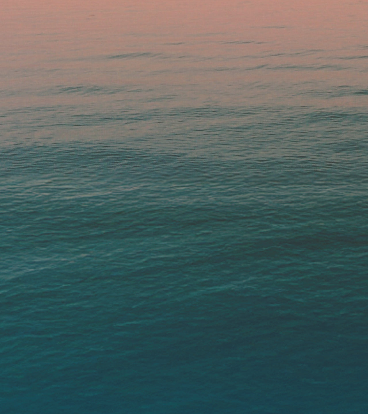 Calm ocean surface with a gradient sky at sunset