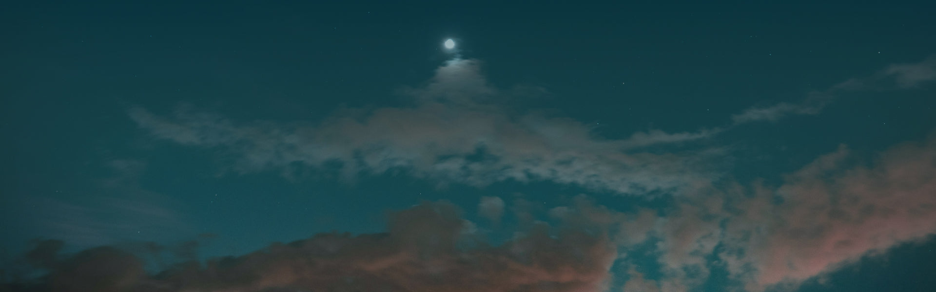Crescent moon and clouds in a dark blue sky