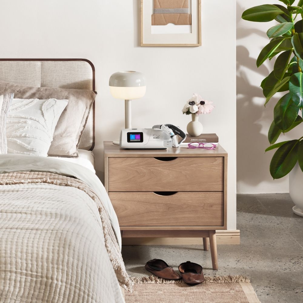 ResMed AirCurve 11 BiPAP machine and CPAP mask on nightstand