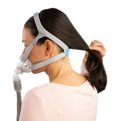 Woman wearing the ResMed AirFit F30i adjusting her hair