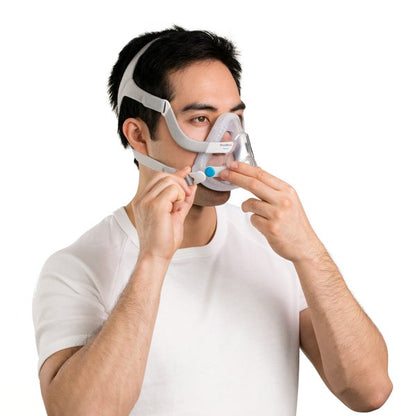 Man putting on the ResMed AirTouch F20 full face CPAP mask