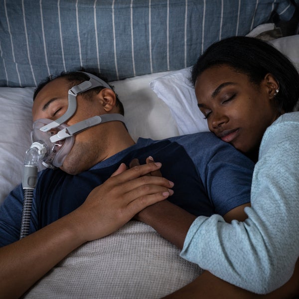 Man sleeping with the ResMed AirTouch F20 full face CPAP mask on