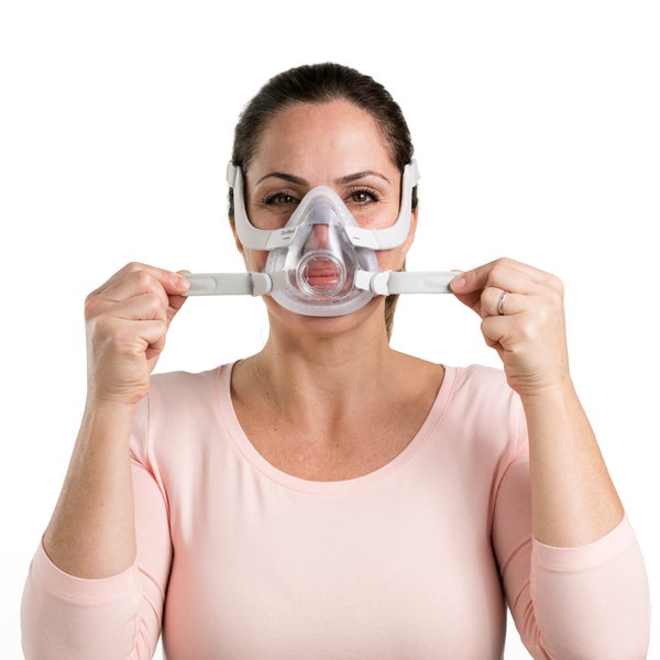 Woman adjusting the straps on the ResMed AirTouch F20 for Her full face CPAP Mask