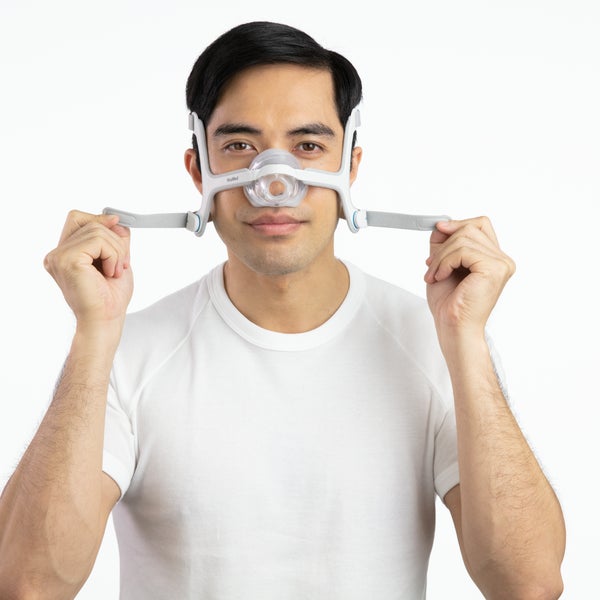 Person adjusting the straps on the ResMed AirTouch N20 Nasal CPAP Mask