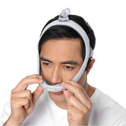 Person adjusting the ResMed AirTouch N30i Nasal CPAP Mask